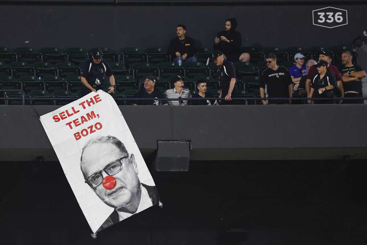 White Sox fans with sign telling Jerry Reinsdorf to sell the team