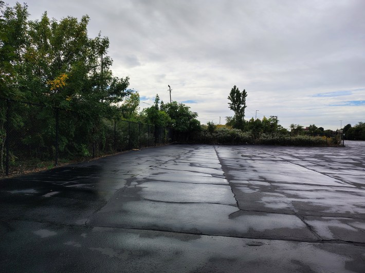 A chain-link fence divides the Union Pacific-vacated railyard and Rate Field's Lot G. Amtrak has plans purchasing the railyard to build a new maintenance facility next to Rate Field.