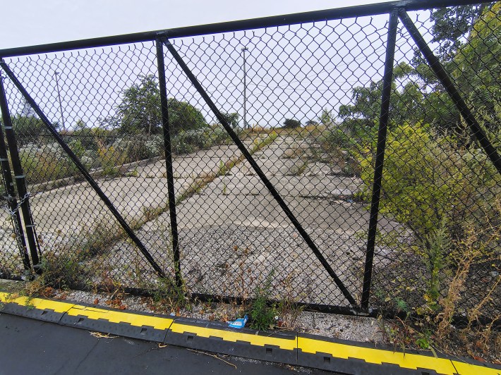 The locked gate is blocking access from Rate Field's Lot G to the railyard. Currently owned by Union Pacific, Amtrak has plans in using the ramp for their future maintenance facility
